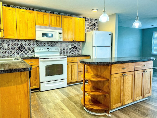 kitchen featuring white appliances, a center island, and light wood-type flooring