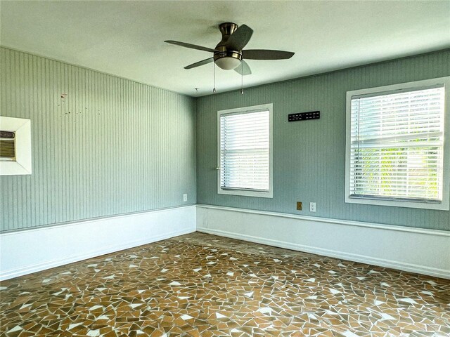 spare room featuring ceiling fan and a healthy amount of sunlight