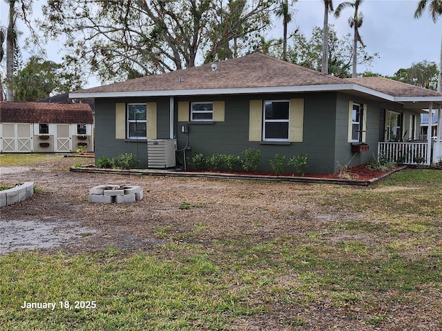 view of front of house featuring central AC and a storage unit