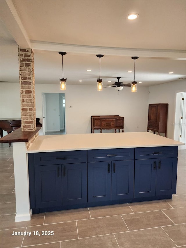 kitchen featuring decorative columns, decorative light fixtures, and blue cabinetry