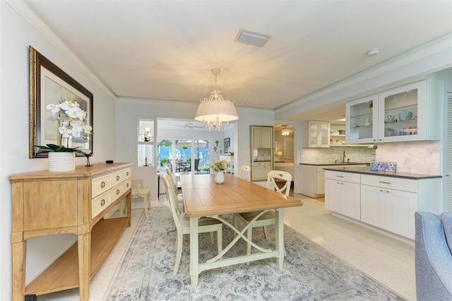 dining area featuring an inviting chandelier and ornamental molding