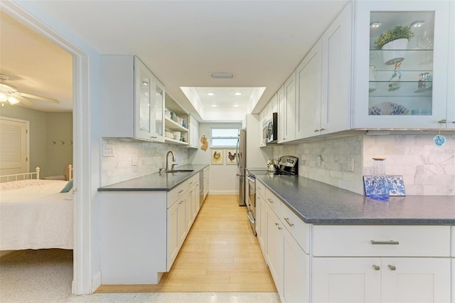 kitchen featuring sink, white cabinets, a raised ceiling, and stainless steel appliances