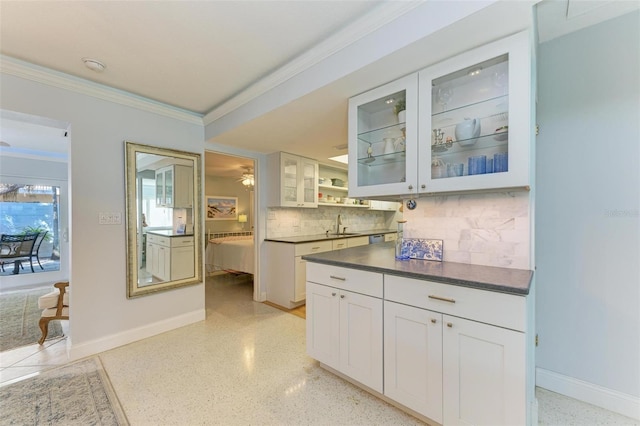 kitchen featuring sink, white cabinets, tasteful backsplash, and ornamental molding