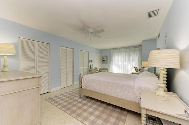 bedroom with ceiling fan and two closets