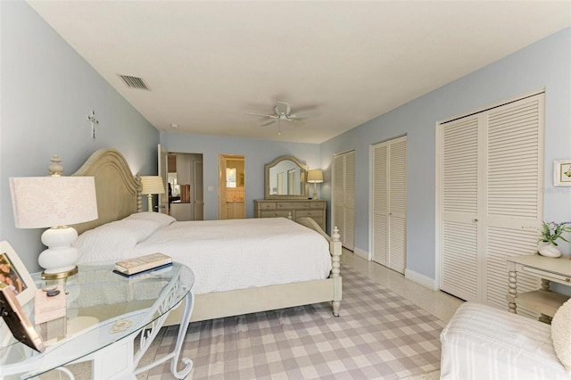 carpeted bedroom with ceiling fan and two closets