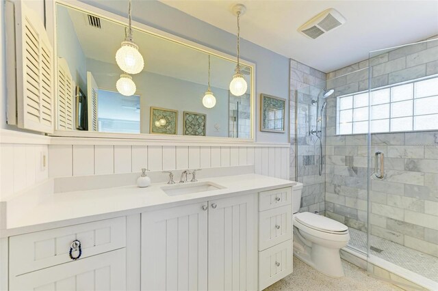 bathroom with toilet, a shower with shower door, and vanity