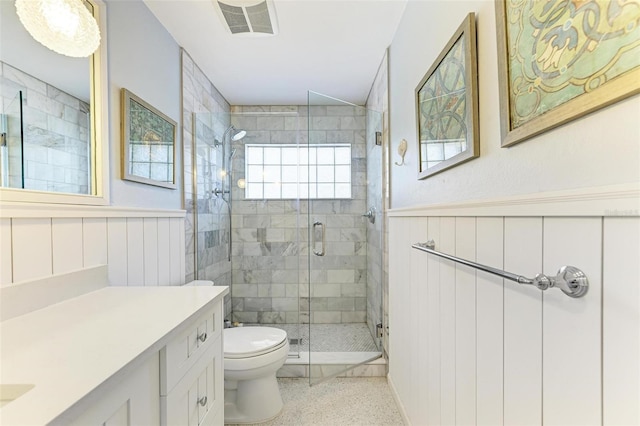 bathroom featuring toilet, a shower with door, and vanity