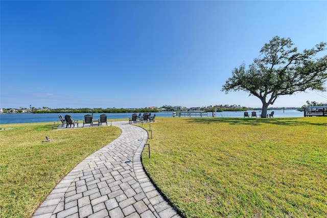 view of property's community featuring a water view and a lawn