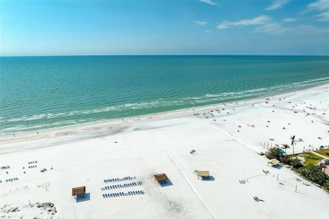 birds eye view of property with a water view and a beach view