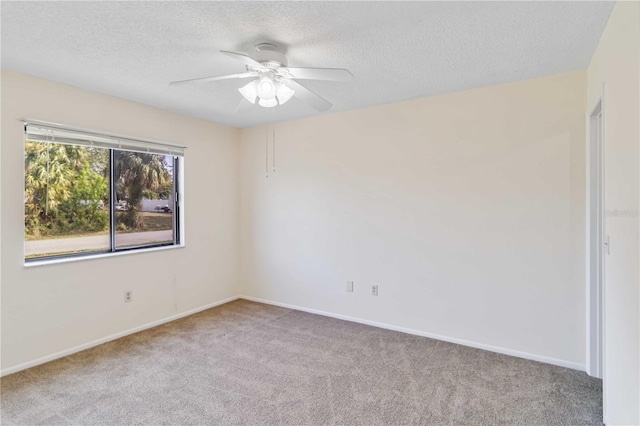 carpeted spare room featuring a textured ceiling and ceiling fan