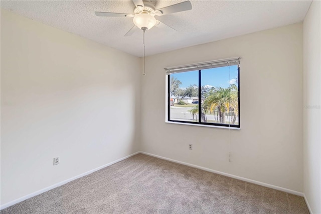 carpeted spare room featuring ceiling fan and a textured ceiling