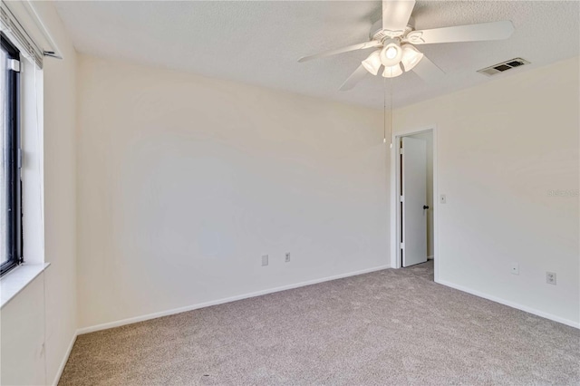 spare room featuring light carpet and ceiling fan