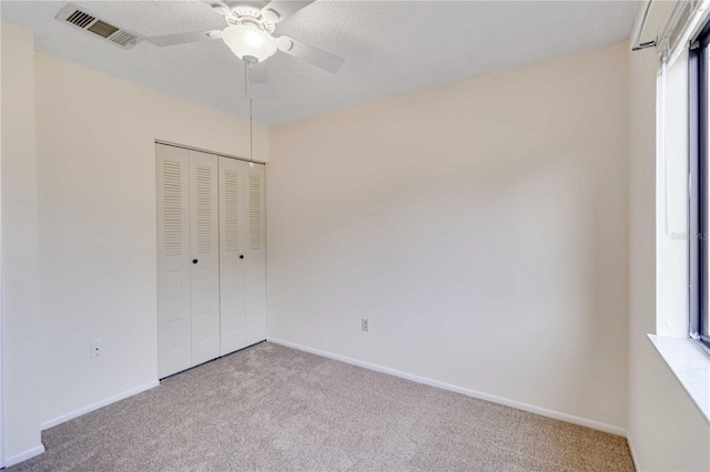 unfurnished bedroom featuring ceiling fan, a closet, light carpet, and multiple windows