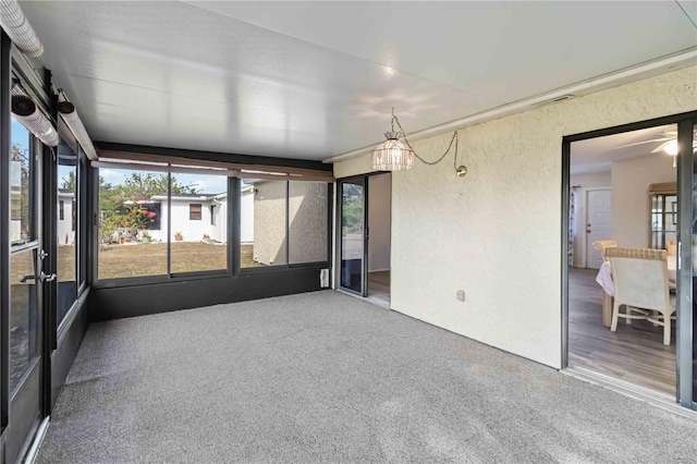 unfurnished sunroom with ceiling fan