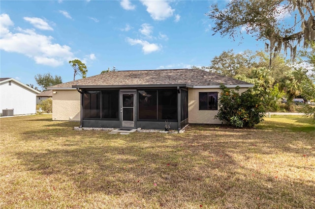 rear view of property featuring a lawn, central air condition unit, and a sunroom