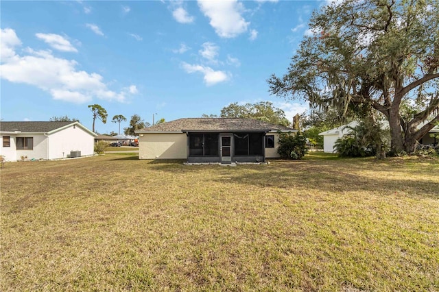 rear view of property featuring a lawn and a sunroom