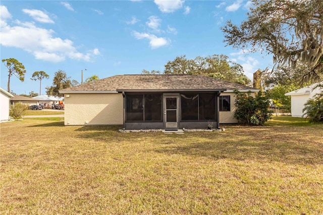 rear view of property featuring a yard and a sunroom