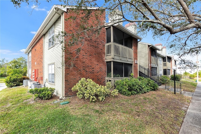 view of property exterior featuring a balcony and a yard