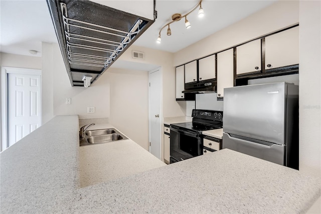 kitchen with electric range, sink, white cabinetry, and stainless steel refrigerator