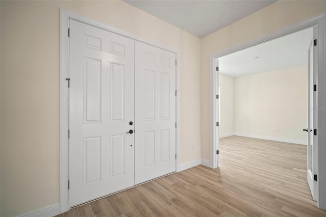 foyer featuring light wood finished floors and baseboards