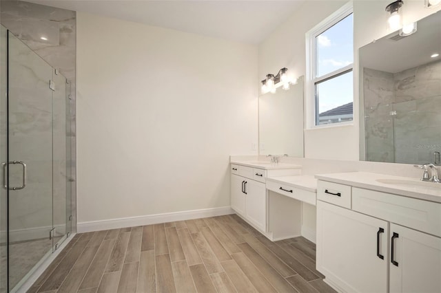 bathroom with baseboards, a shower stall, wood finish floors, and vanity
