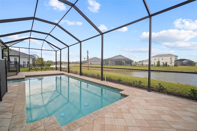 outdoor pool with glass enclosure, a residential view, a patio area, and a water view