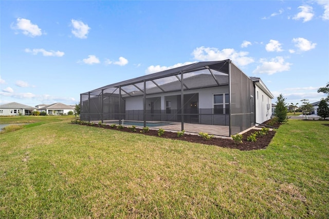 back of house featuring a lawn and glass enclosure