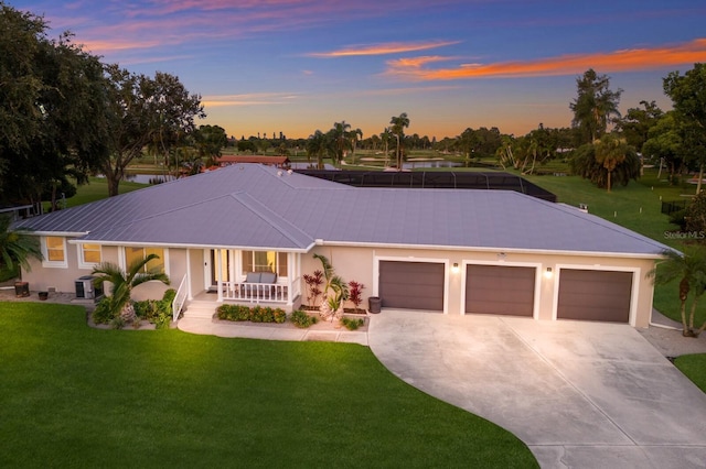 view of front of property with a garage, a porch, cooling unit, and a lawn