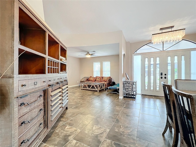 entryway with ceiling fan with notable chandelier