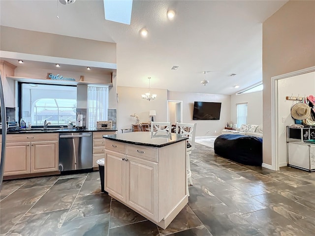 kitchen featuring pendant lighting, a center island, lofted ceiling, a notable chandelier, and stainless steel dishwasher