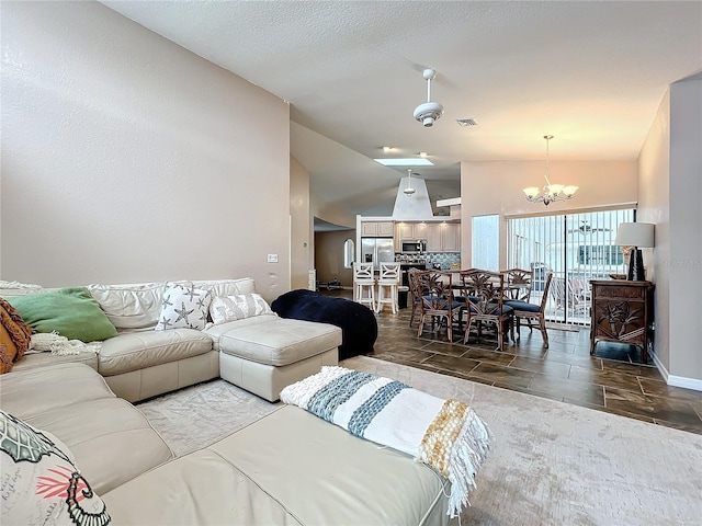 living room featuring lofted ceiling and a notable chandelier