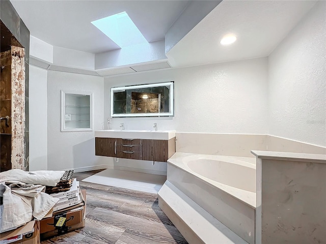 bathroom featuring a bathing tub, hardwood / wood-style flooring, vanity, and built in shelves