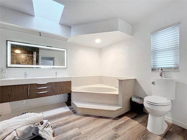 bathroom with toilet, a bathing tub, hardwood / wood-style flooring, and vanity