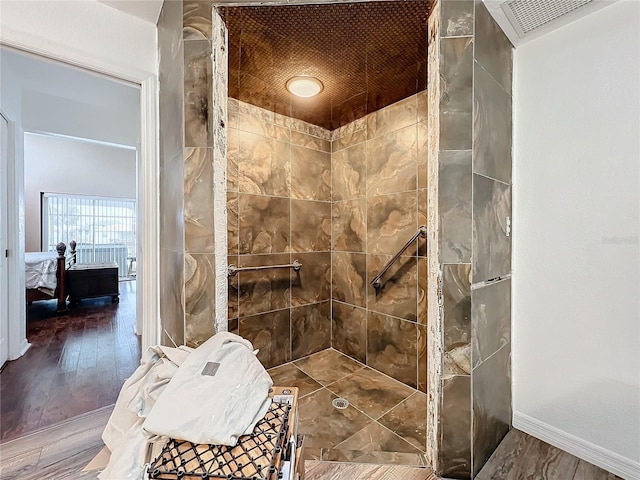 bathroom with wood-type flooring, wood ceiling, and tiled shower