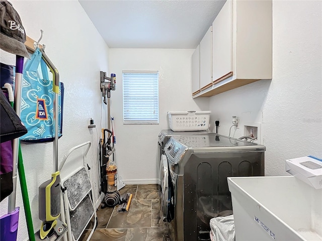 laundry room featuring cabinets, separate washer and dryer, and dark tile patterned flooring