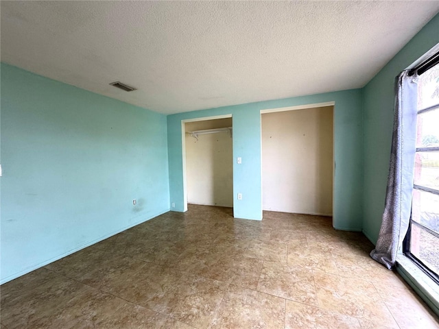 unfurnished bedroom with a textured ceiling