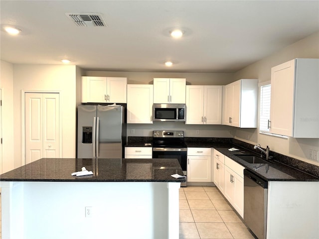 kitchen featuring white cabinets, dark stone counters, sink, and stainless steel appliances