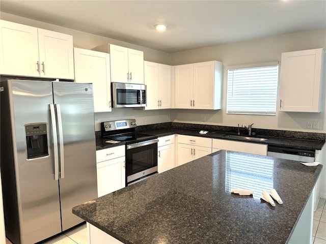 kitchen with appliances with stainless steel finishes, a center island, white cabinets, and sink