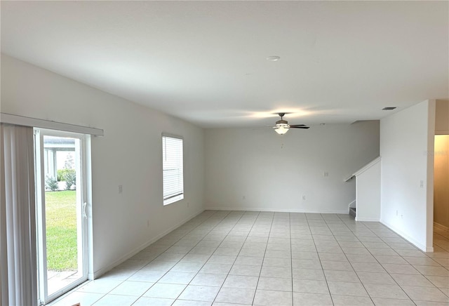 tiled empty room featuring ceiling fan