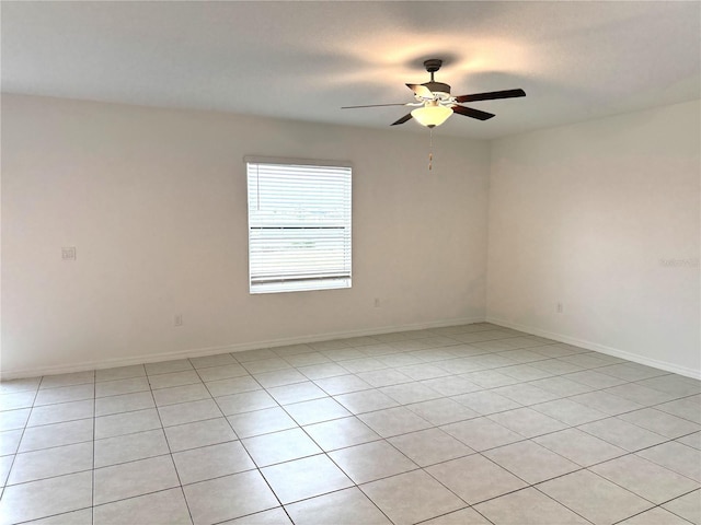 tiled spare room featuring ceiling fan