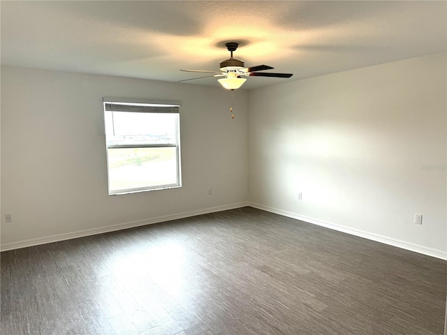 spare room with ceiling fan and dark hardwood / wood-style floors