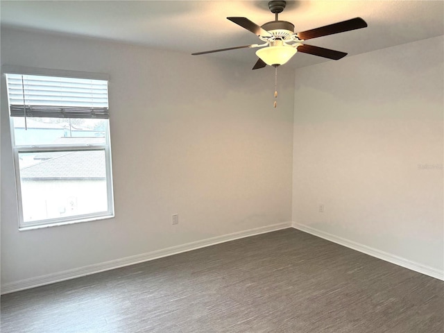 empty room with ceiling fan, a wealth of natural light, and dark hardwood / wood-style floors