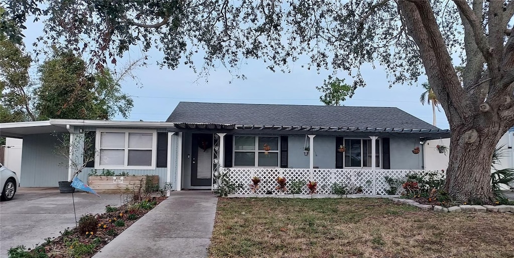 single story home featuring a front lawn and a carport