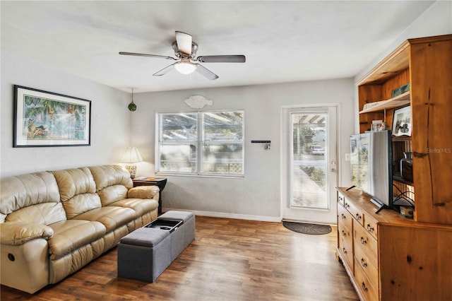 living room featuring dark wood-type flooring and ceiling fan