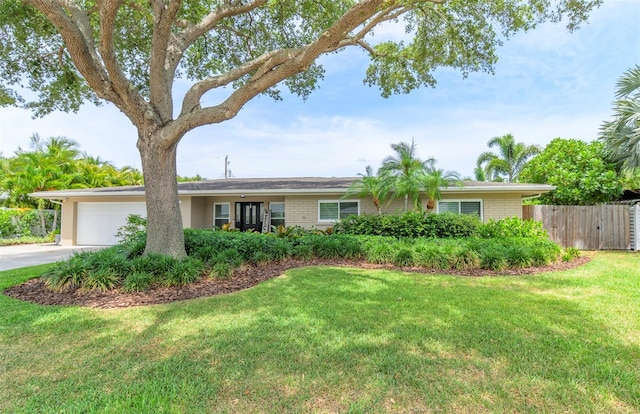 single story home featuring a garage and a front yard