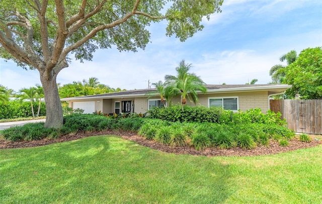 ranch-style home with a front lawn and a garage