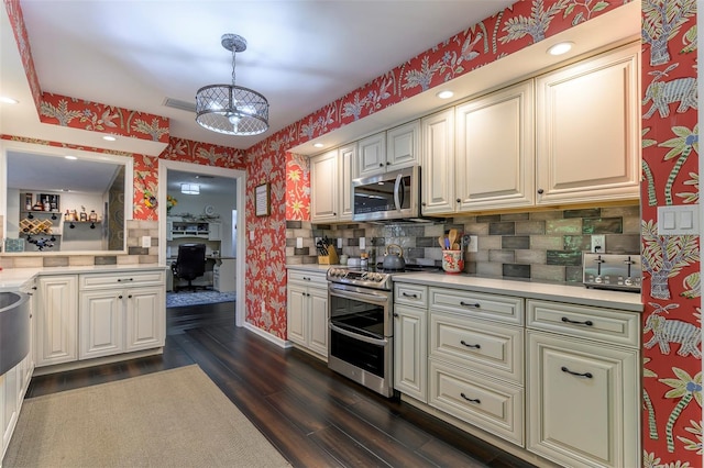 kitchen featuring an inviting chandelier, stainless steel appliances, decorative backsplash, dark hardwood / wood-style floors, and hanging light fixtures