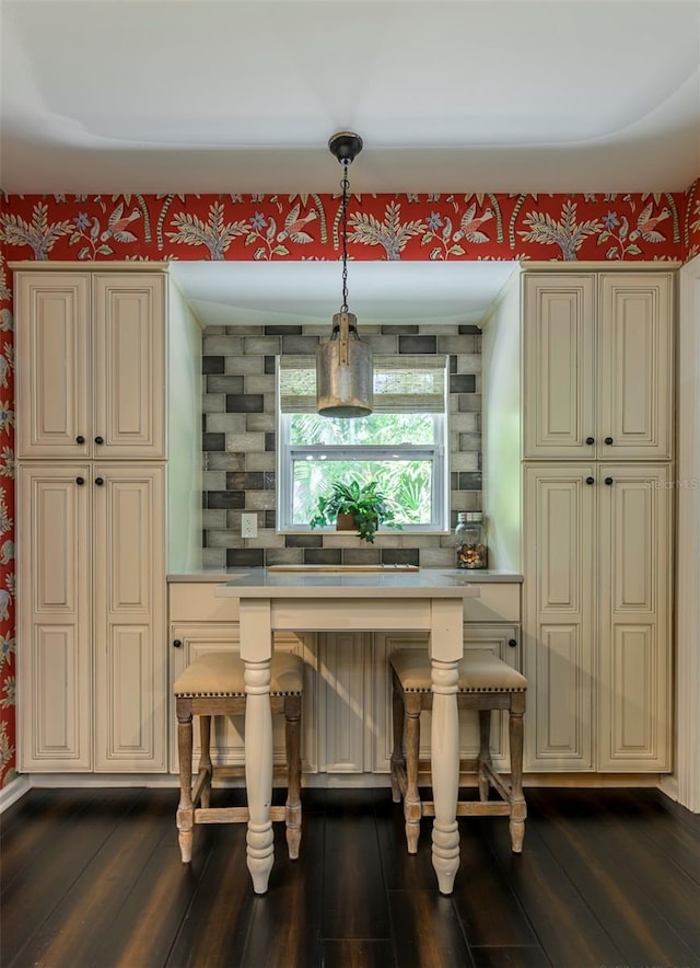 bar with pendant lighting, cream cabinetry, and dark hardwood / wood-style floors