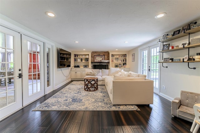 living room with built in features, french doors, dark wood-type flooring, and a textured ceiling