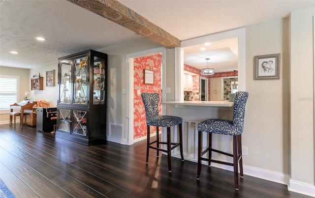 bar with dark hardwood / wood-style floors